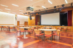 Interior image of the Trojan Grand Ballroom with screen down and banquet round tables